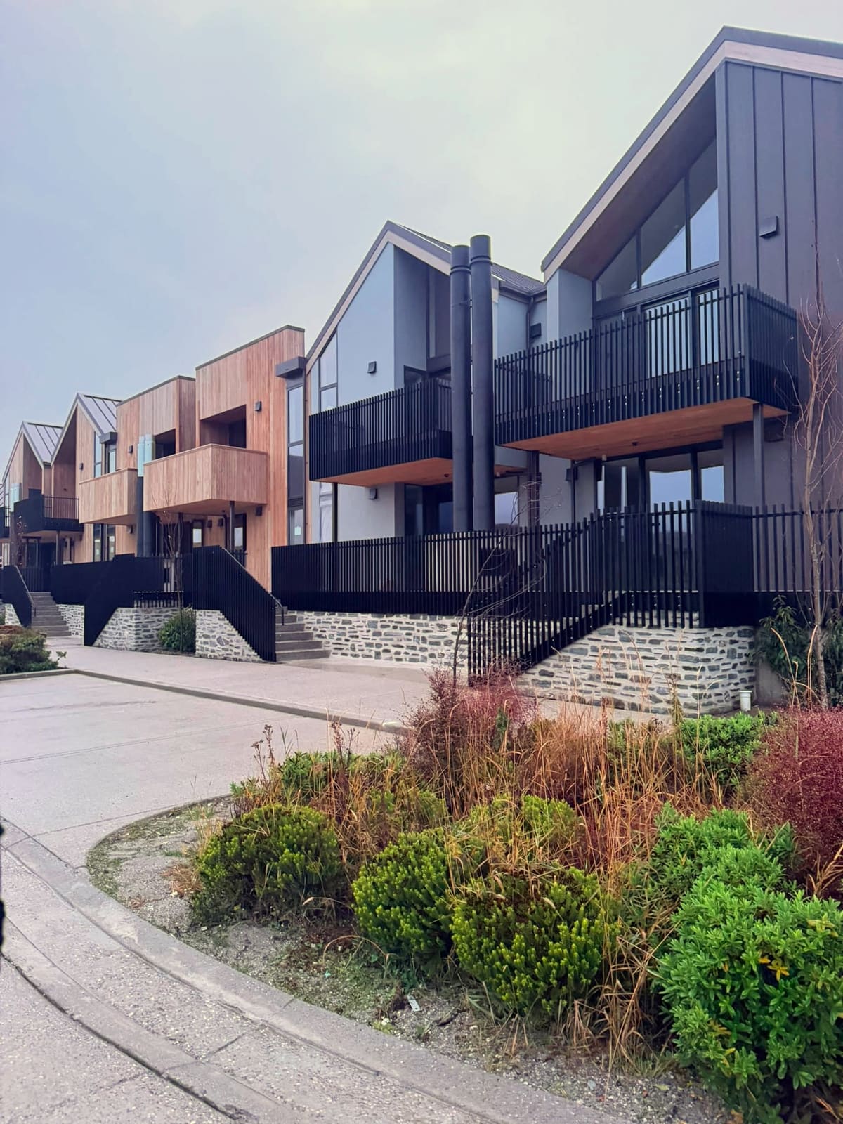 Black aluminium balustrades along the decks and steps of modern Queenstown townhouses