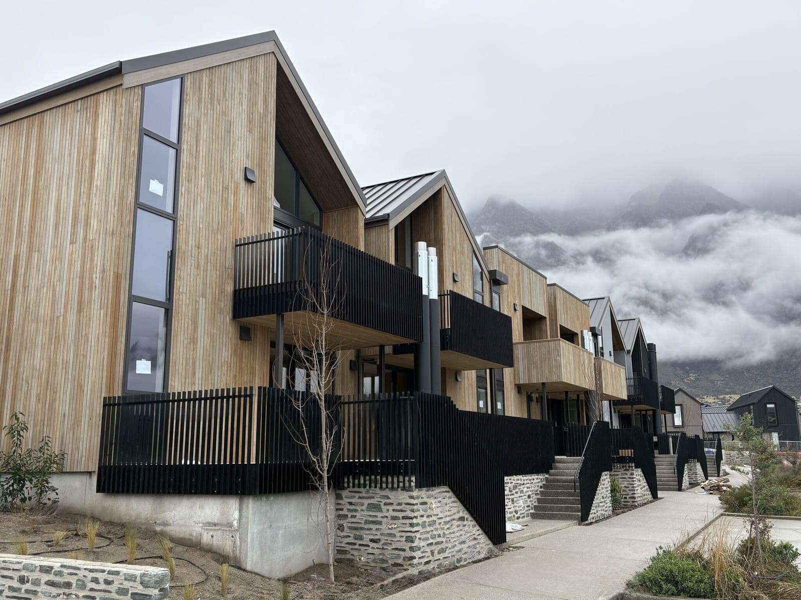 Black aluminium slat balustrades along a row of cedar townhouses, Arthurs Point