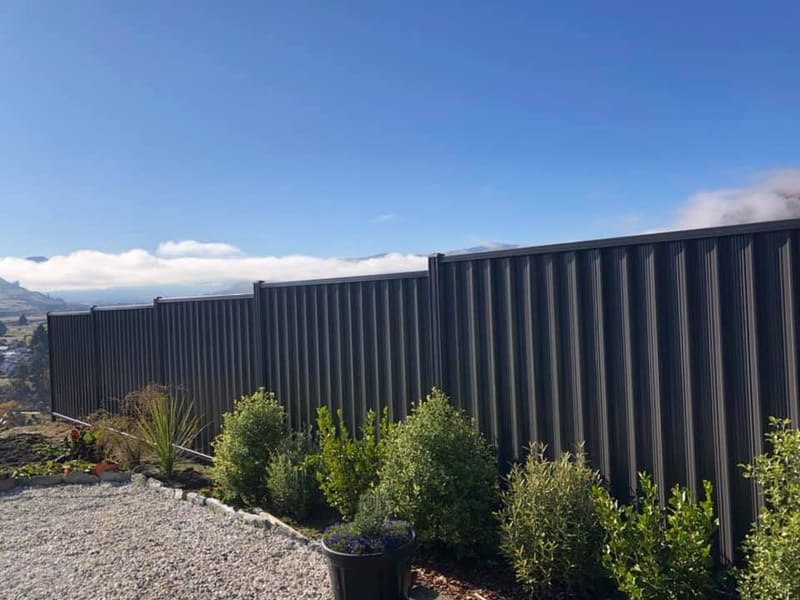 Dark colour panel fencing beside a garden with mountain views, Queenstown