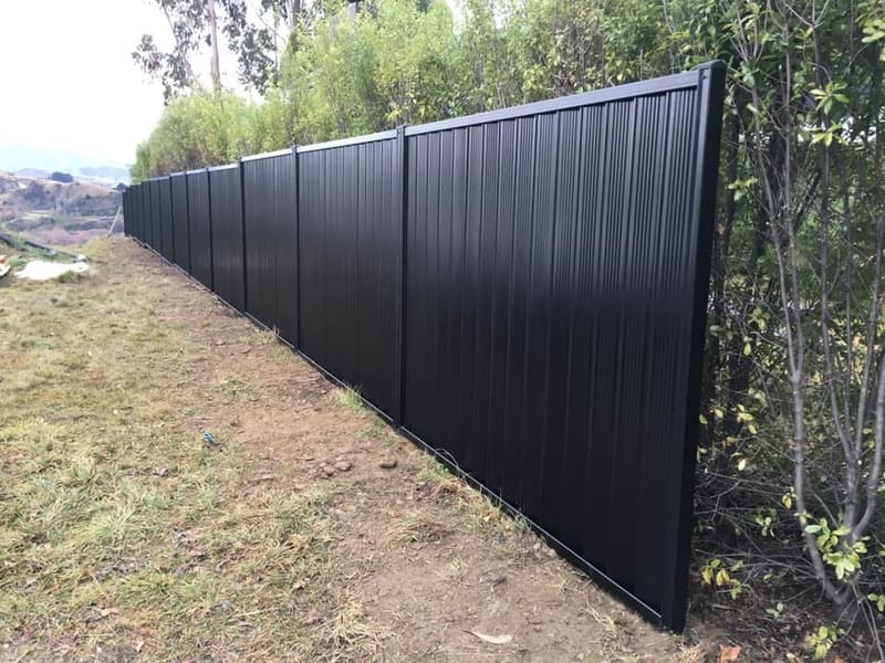 Dark colour steel panel fencing on a hillside section, Queenstown