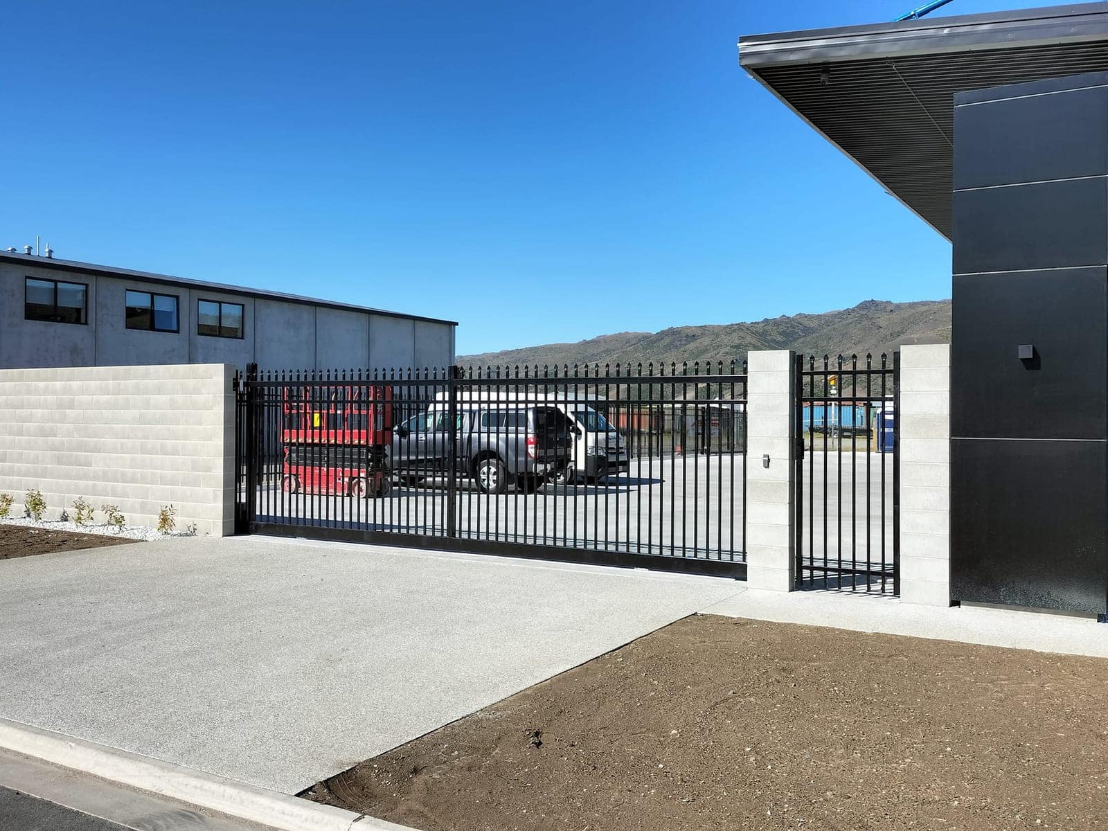 Black automatic sliding gate securing a commercial yard, Queenstown