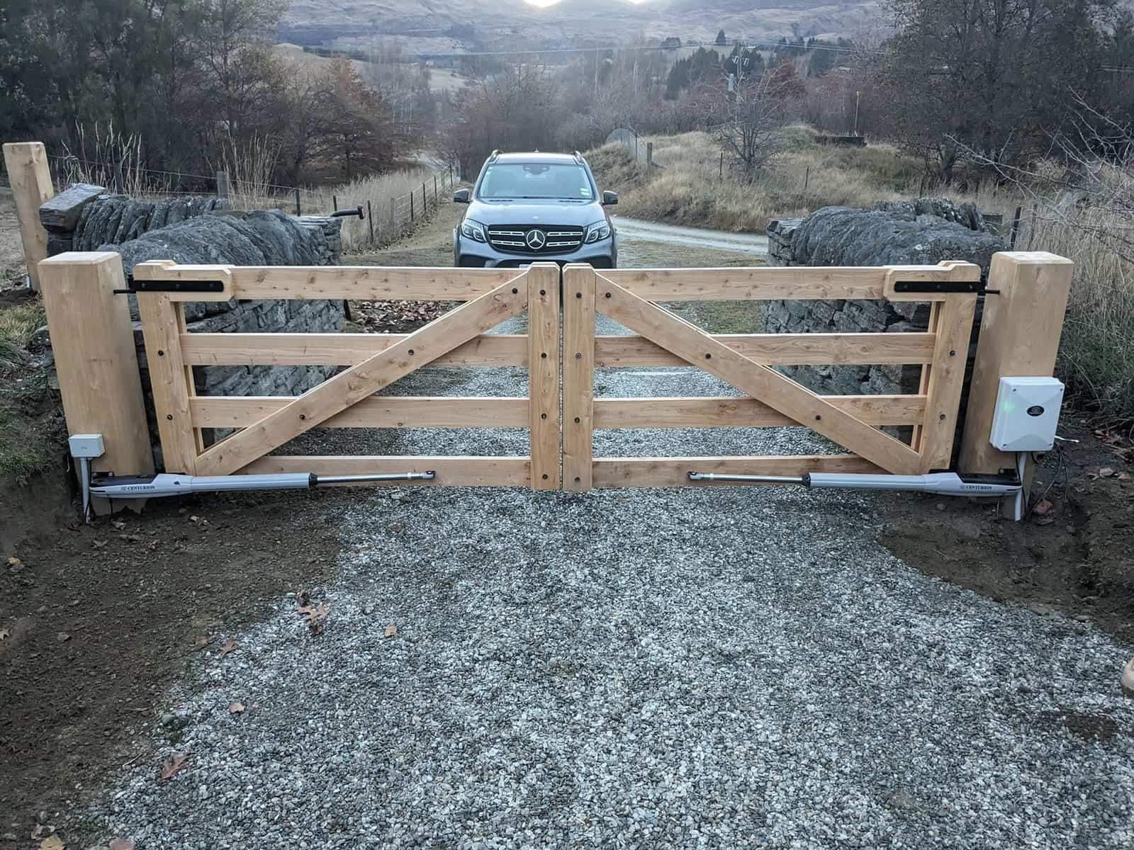 Macrocarpa double gate on a rural driveway with mountains in the background, Central Otago