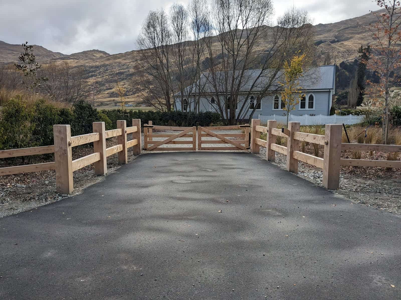 Timber double driveway gate with matching post and rail fencing on a rural Central Otago entrance