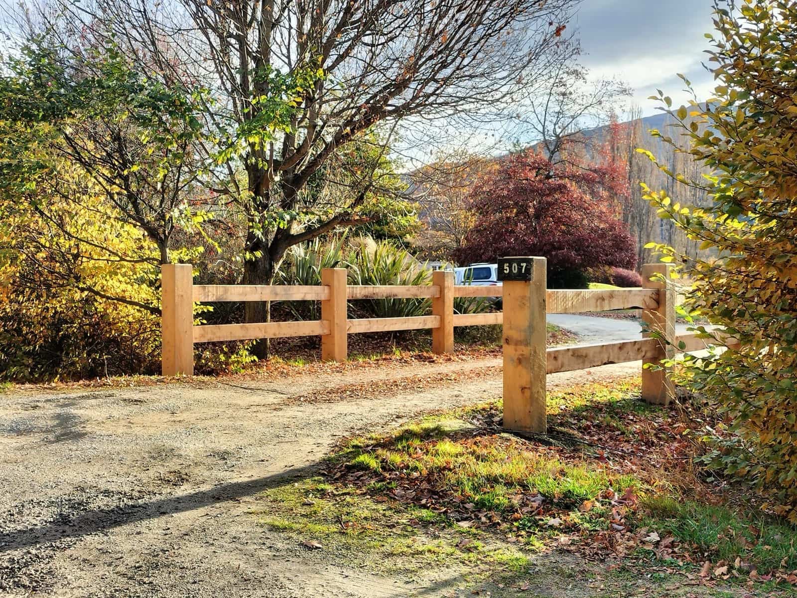 Macrocarpa post and rail with letterbox in autumn foliage, Arrowtown
