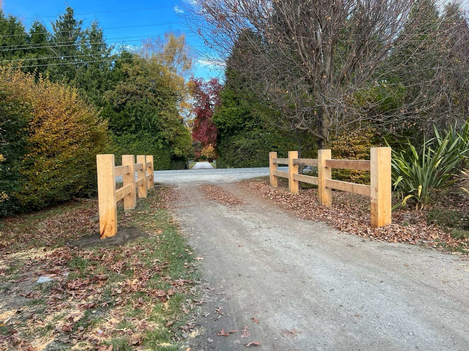 Macrocarpa post and rail driveway entrance framed by autumn colour, Arrowtown