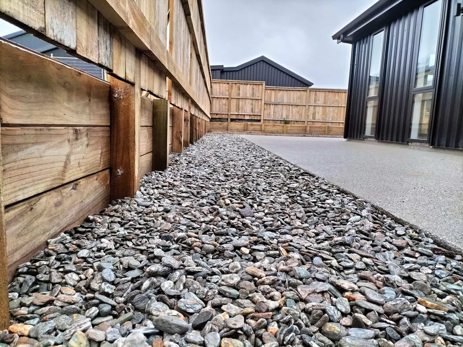 Timber retaining wall with paling fencing above it on a Queenstown new build