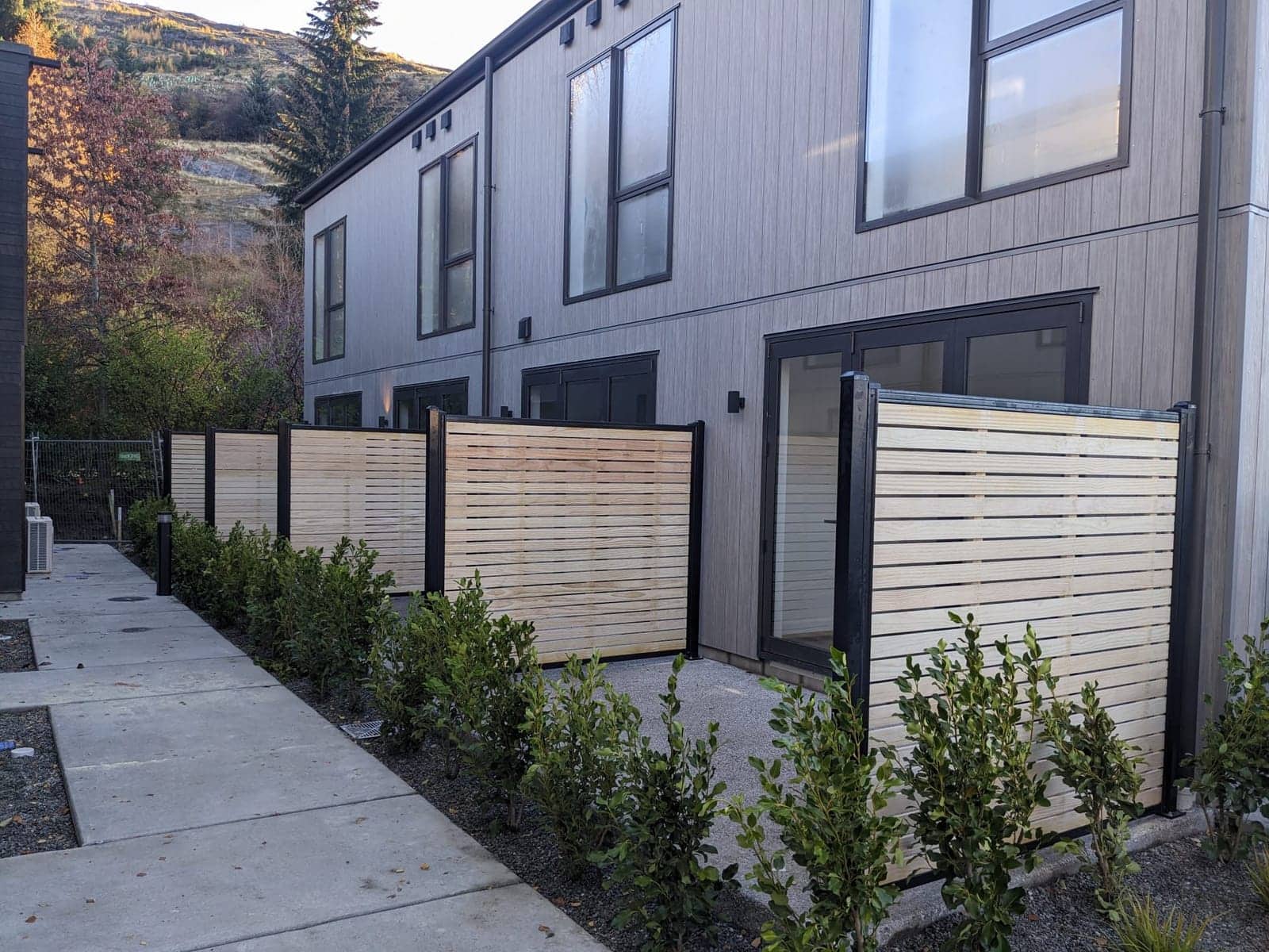Pale cedar horizontal slat fence along modern townhouses, Queenstown