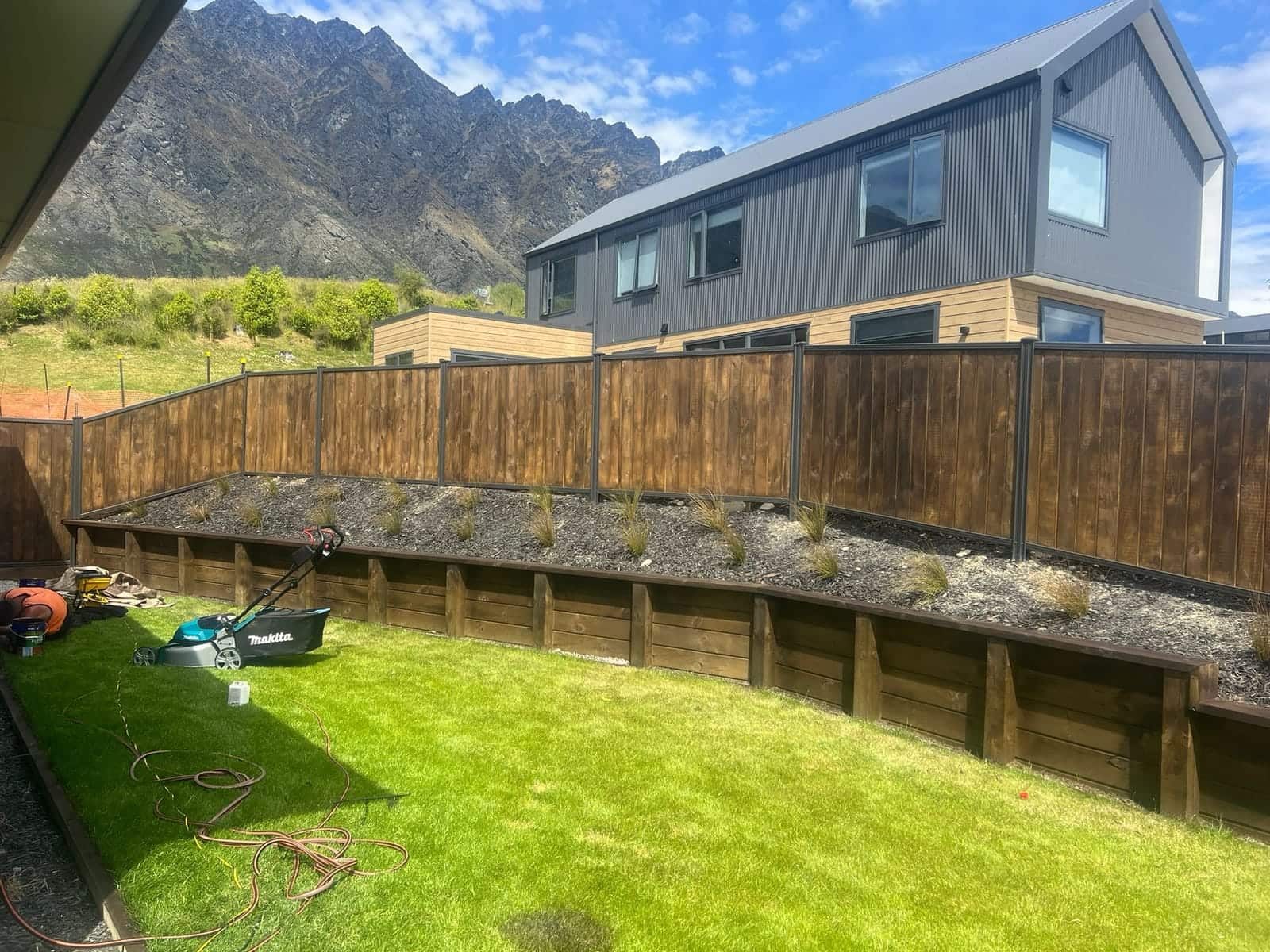 Dark smart wall fencing enclosing a garden with mountain views, Queenstown