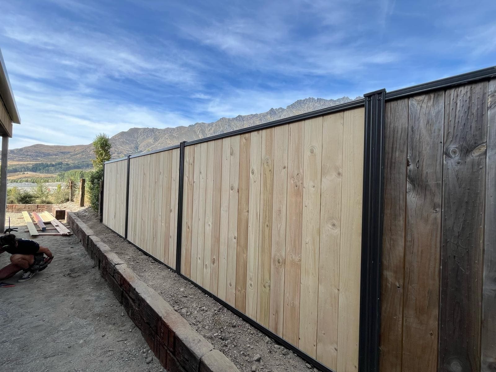 Smart Wall fencing with timber palings in a black aluminium frame, with Queenstown mountains behind